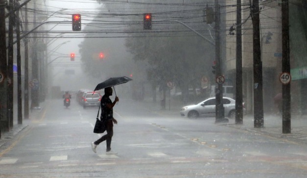 homem andando na chuva para ilustrar a chegada de uma nova frente fria no Paraná