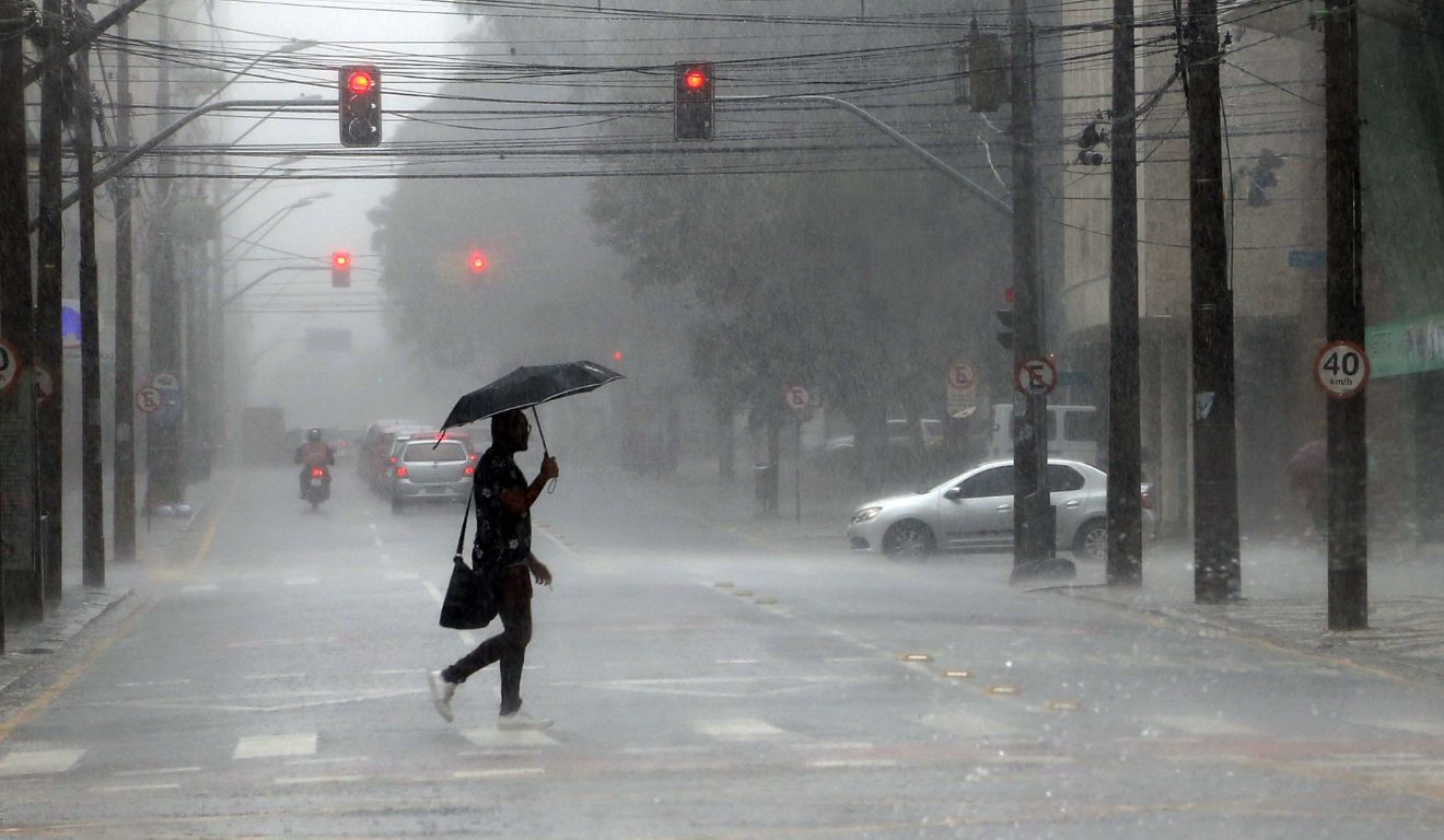 homem andando na chuva para ilustrar a chegada de uma nova frente fria no Paraná