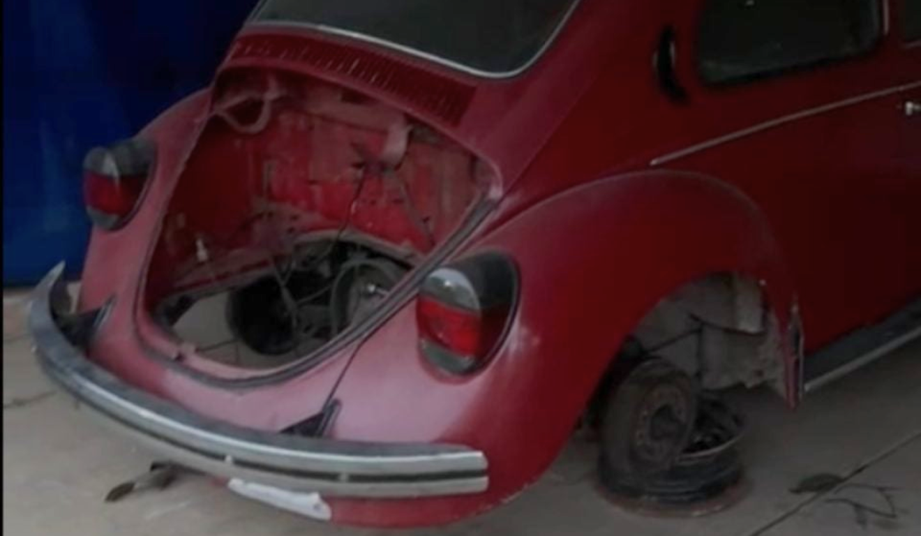 Dois irmãos foram torturados após tentarem roubar rodas de um fusca em São José dos Pinhais. Na imagem, vemos o fusca vermelho sem algumas peças, como o motor e as rodas.