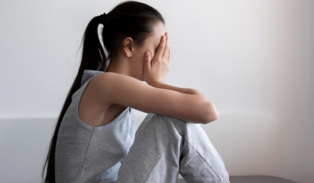 Jovem triste na cama para ilustrar irmã abusada por jovem