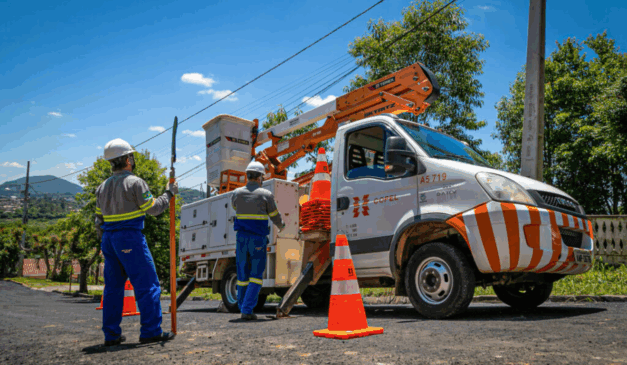 Caminhão e funcionários da Copel trabalhando.