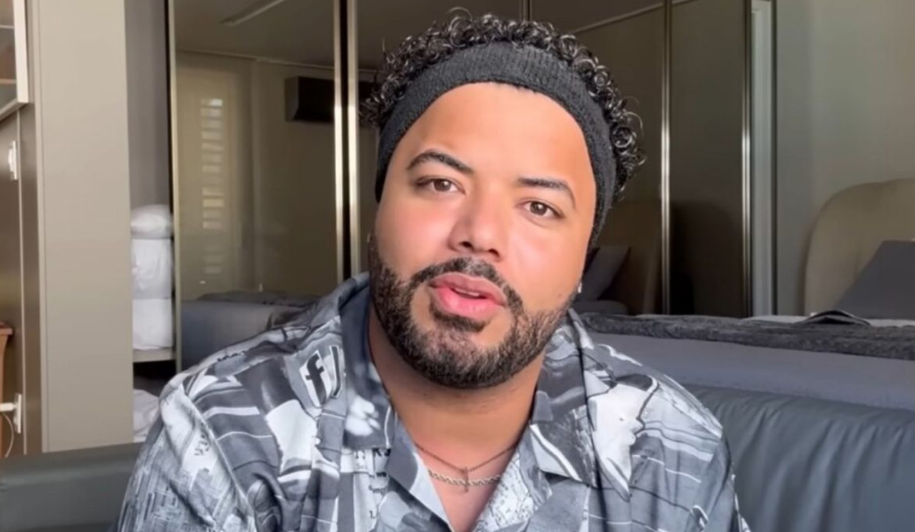 O Ministério Público do Trabalho da Paraíba pediu o bloqueio dos bens de Hytalo Santos. Na imagem, vemos o influenciador em foto posada. Ele é um homem negro, de barba e cabelos pretos. Hytalo usa uma faixa preta na cabeça e uma camisa cinza.