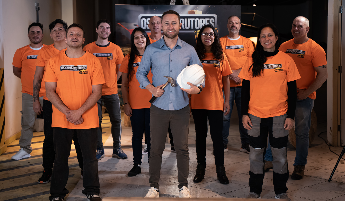 Willian Bittar com capacete de obras, sorrindo ao lado dos participantes