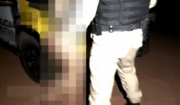 Policial militar de costas com mulher à sua frente, com efeito de borrão.