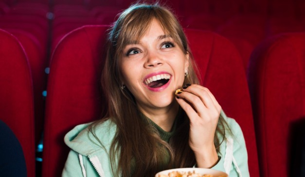 Mulher comendo pipoca.