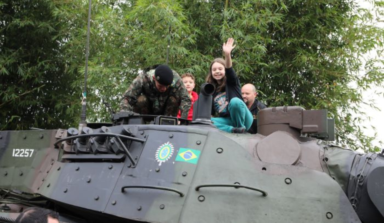 crianças em um blindado do exército