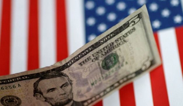 Dolar em frente a uma bandeira dos Estados Unidos