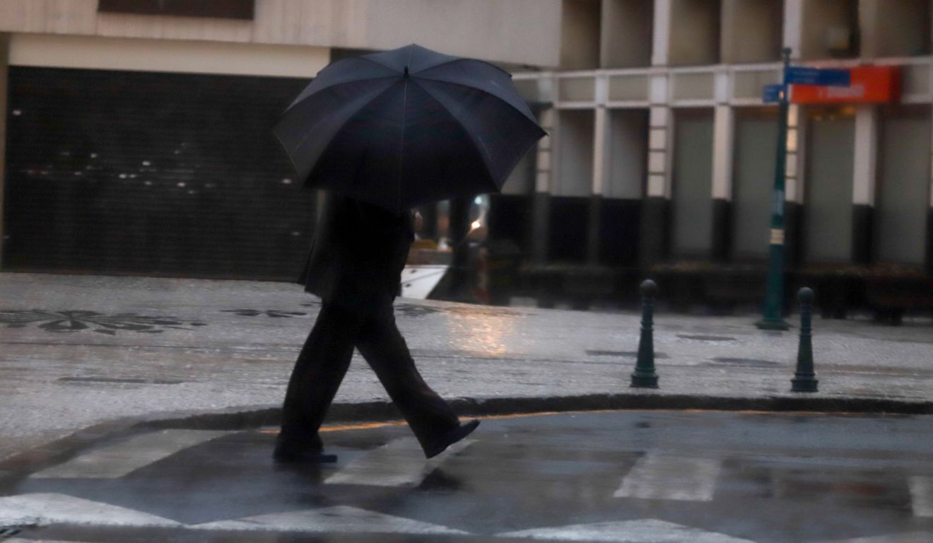 pessoa andando na chuva para ilustrar a previsão de tempestade no Paraná 