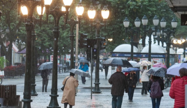 Pessoas andando na chuva.