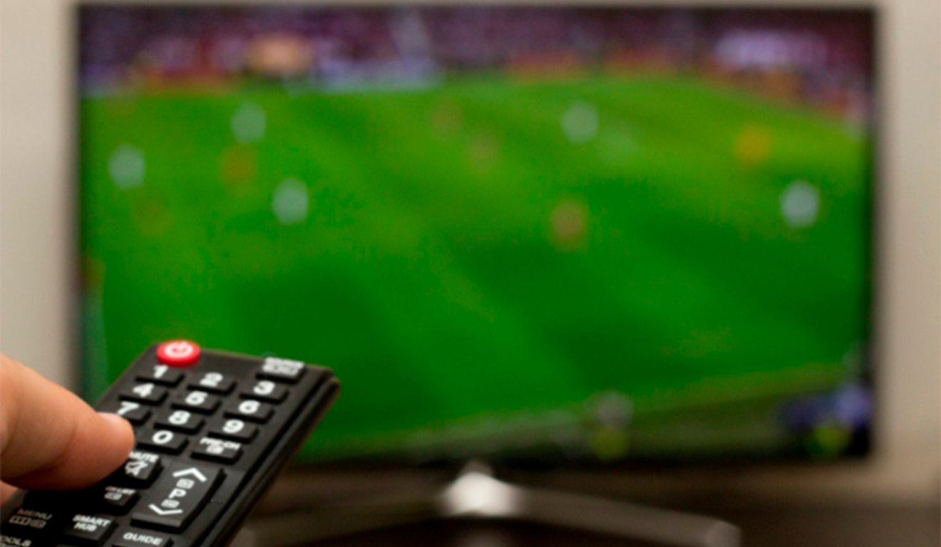 Imagem de um controle de televisão e um canal de futebol