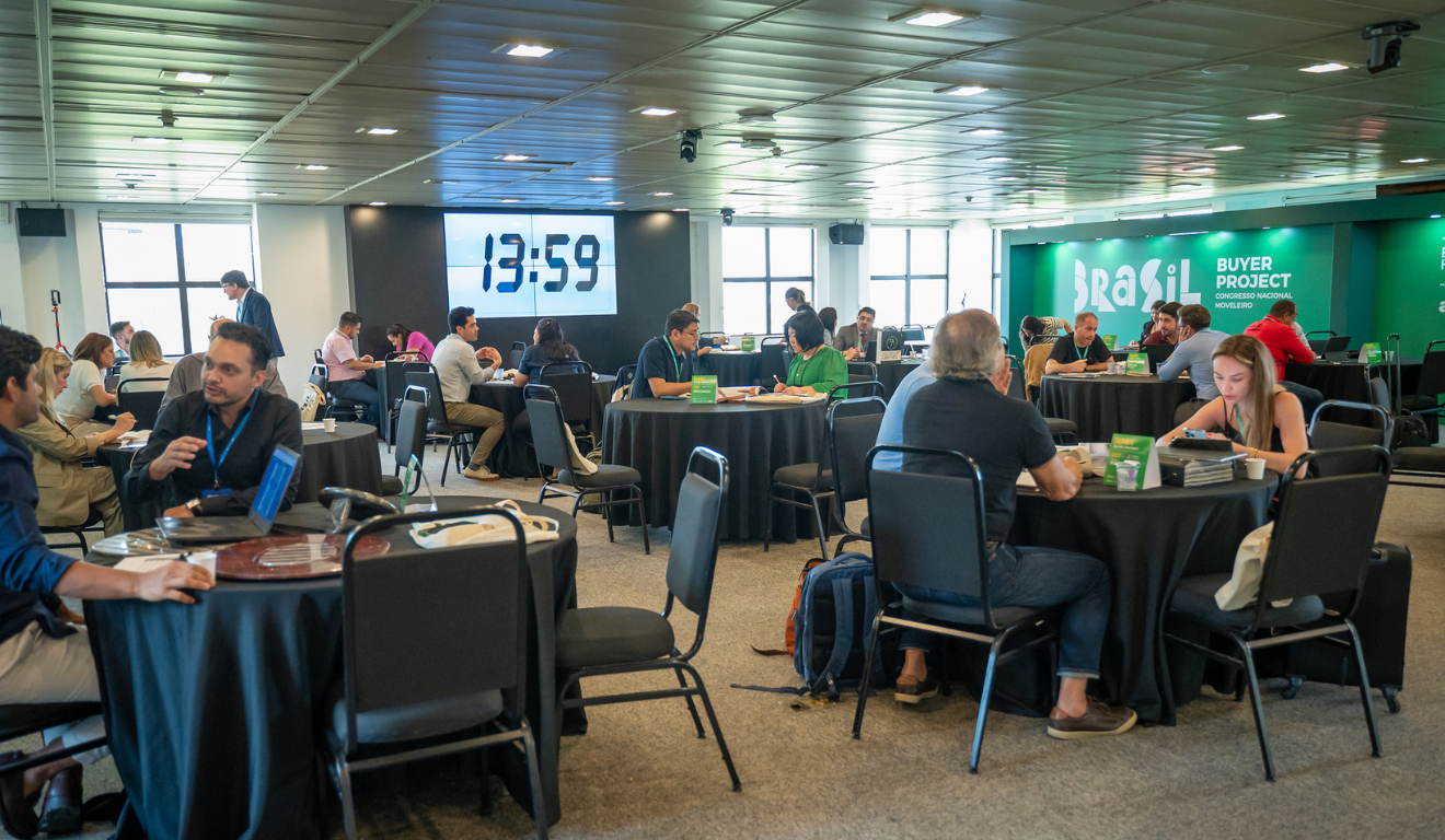 Rodadas de negócios (espaço com mesas e pessoas conversando)
