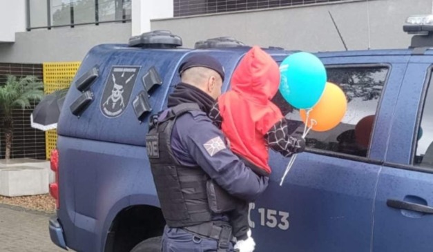 Guarda Municipal com bebê encontrado sozinho segurando balões