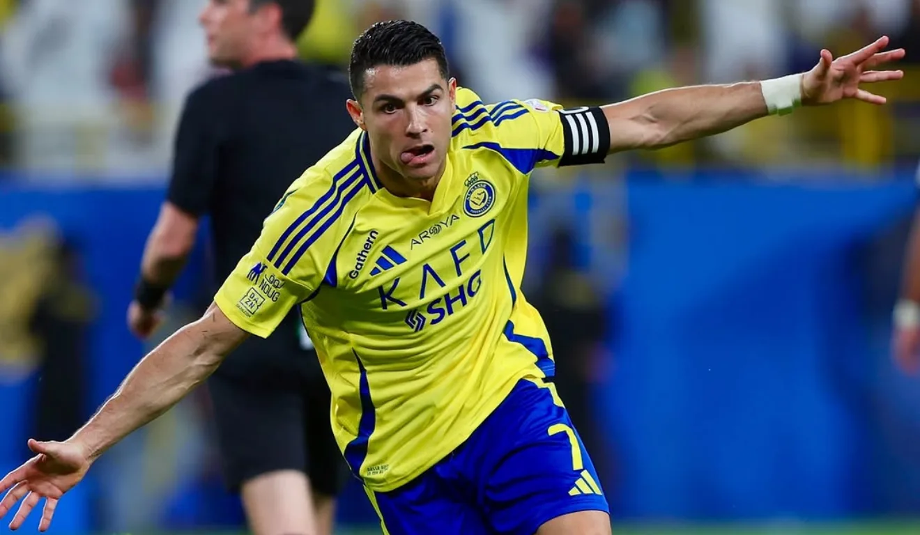Cristiano Ronaldo está em busca de atinigir os 1000 gols na carreira. Na imagem, vemos ele com o uniforme do Al-Nassr, com os braços abertos e comemorando um gol.