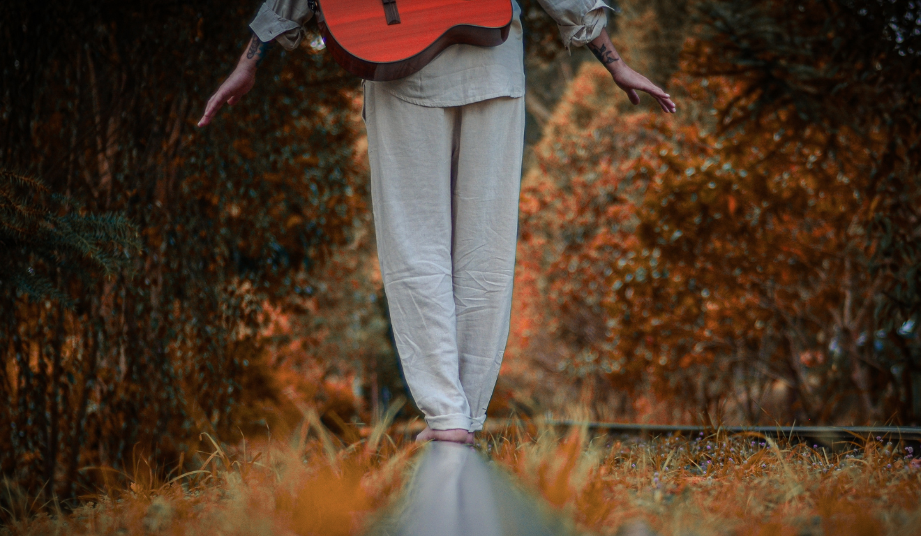 foto do músico Dabliu se equilibrando nos trilhos de trem
