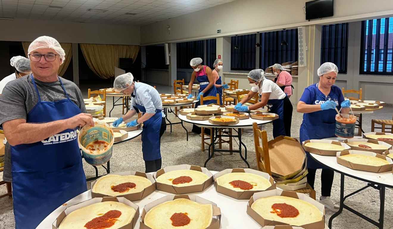 Imagem de pessoas fazendo as pizzas.