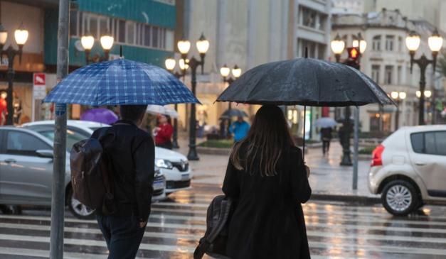 pessoas andando na chuva para ilustrar a chegada da frente fria no Paraná