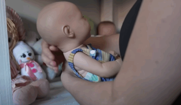 Imagem da vítima segurando uma boneca.