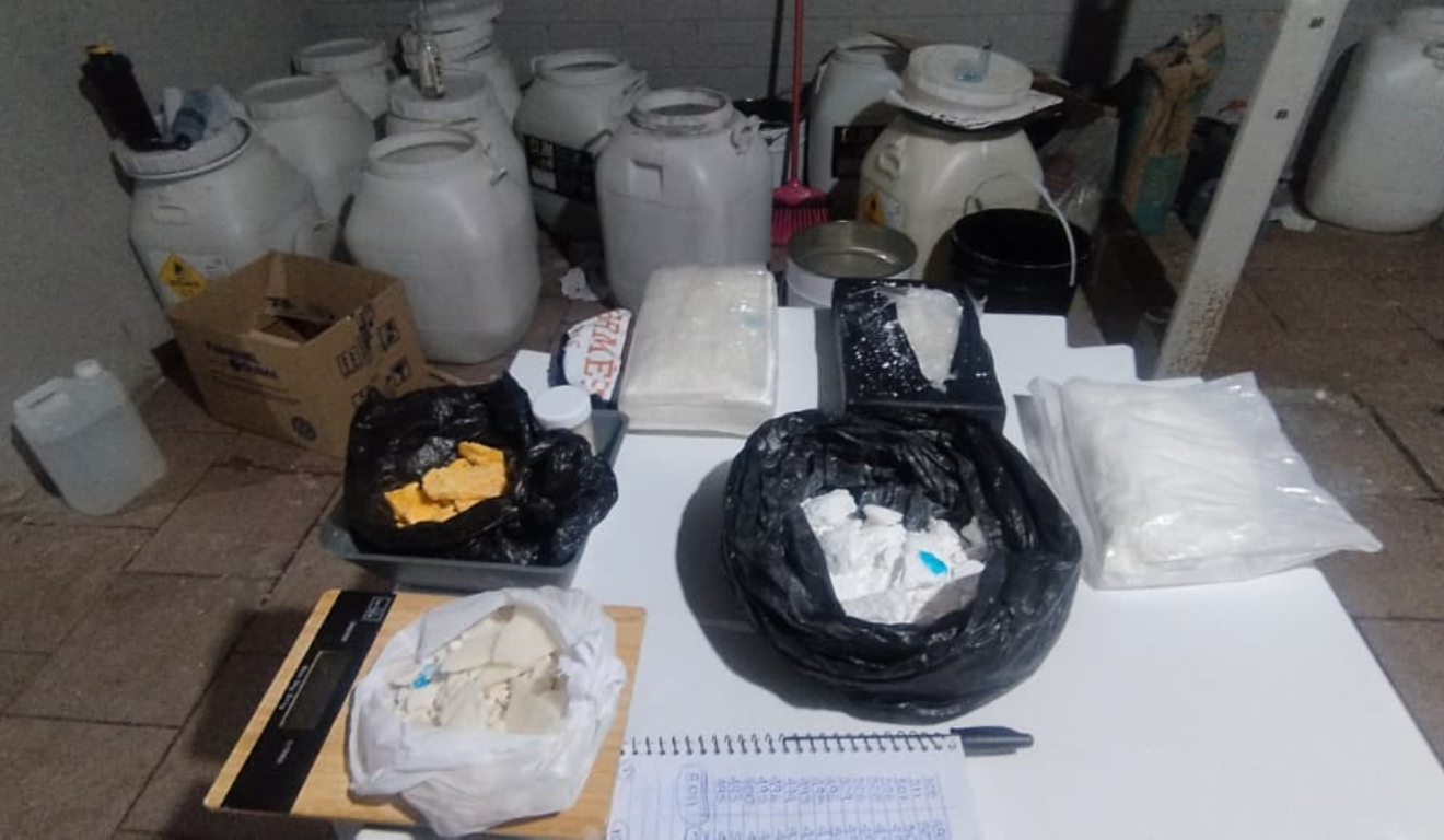 A PM descobriu que um laboratório de cocaína funcionava em São José dos Pinhais. Na imagem, vemos alguns dos materiais apreendidos, como galões, balanças e tabletes da droga.