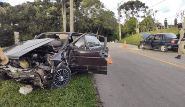 Motorista foge após causar colisão frontal e ferir idoso, mulher e bebê em Curitiba. Na imagem, vemos o Voyage, dirigido pelo motorista e o Corsa, ocupado pelas vítimas, com a parte da frente dos carros destruídas após o acidente.