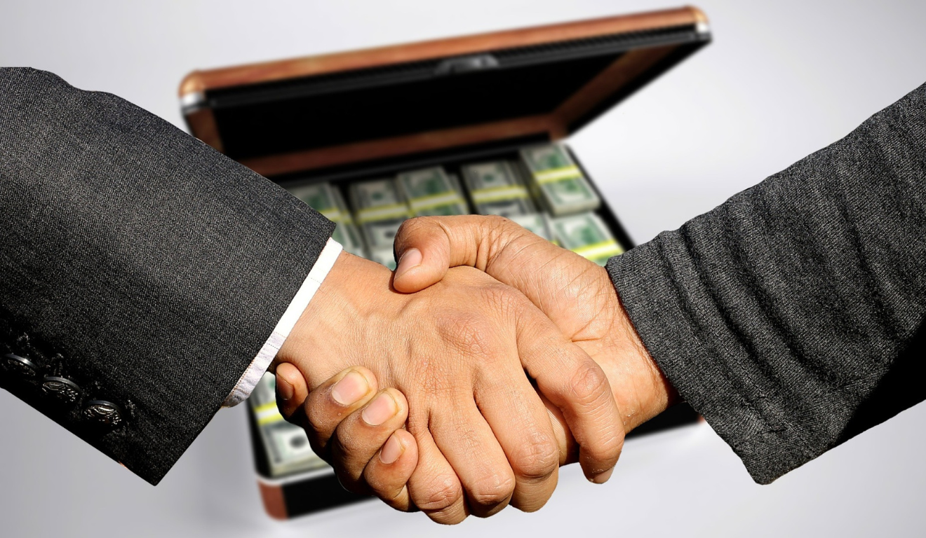homens dando as mãos, ao fundo mala de dinherio, sugerindo corrupção