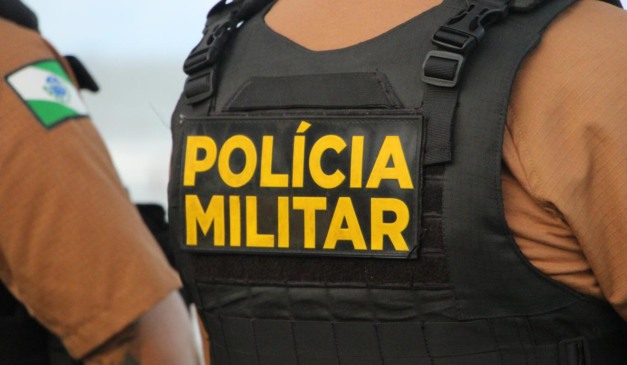 Policial militar de costas usando colete