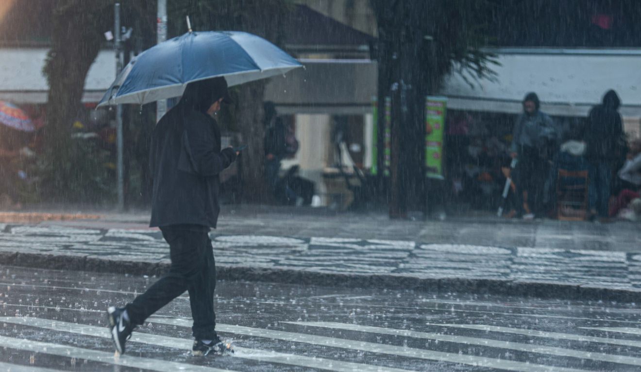 pessoa andando na chuva para ilustrar risco de tempestade no Paraná