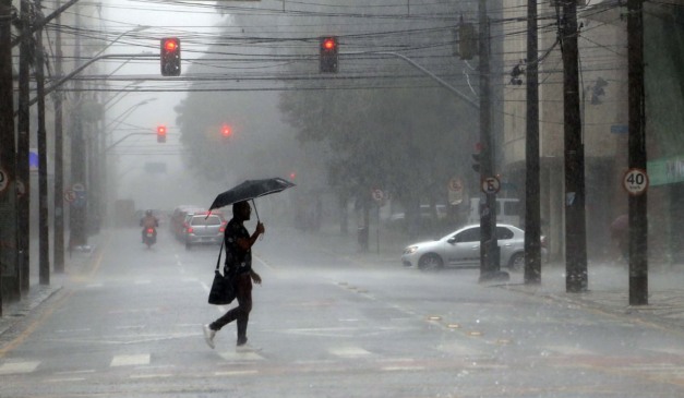 pessoa andando na chuva para ilustrar a previsão de tempestade no Paraná