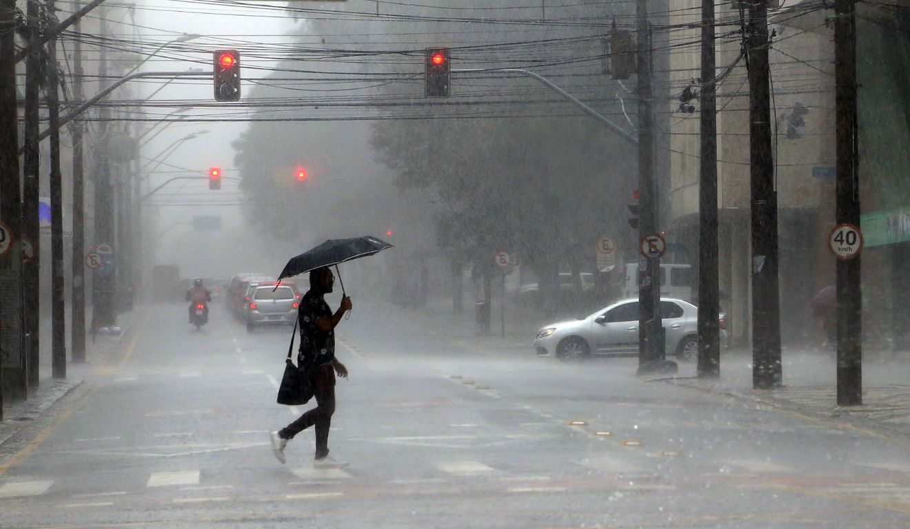 pessoa andando na chuva para ilustrar a previsão de tempestade no Paraná