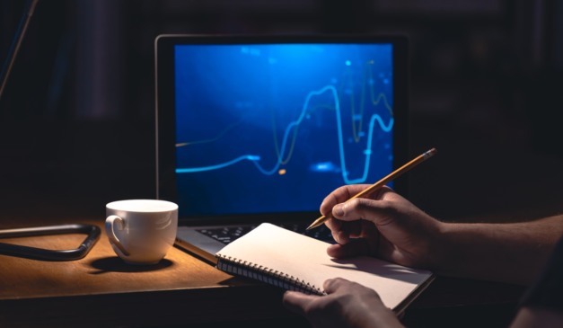 Pessoa escrevendo em caderno.