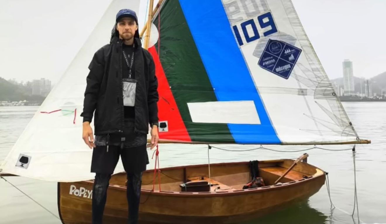 Velejador David Reiser ao lado do barco que naufragou