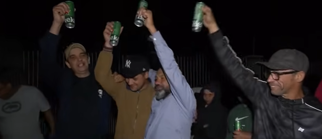 Grupo de pessoas com erguendo latinhas de cerveja