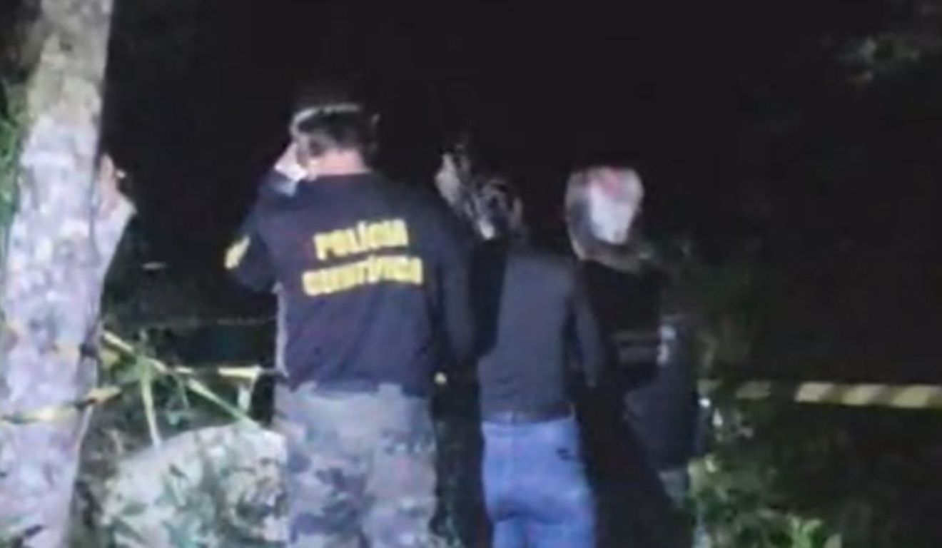 Agentes da Polícia Científica no local em que homem foi encontrado com rosto desfigurado na Grande Curitiba