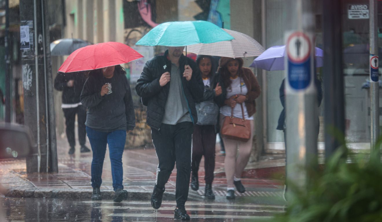 pessoas andando na chuva para ilustrar alerta de chuvas intensas no paraná