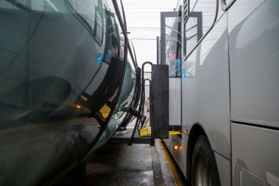 Ônibus encostado em estação-tubo com barreira lateral