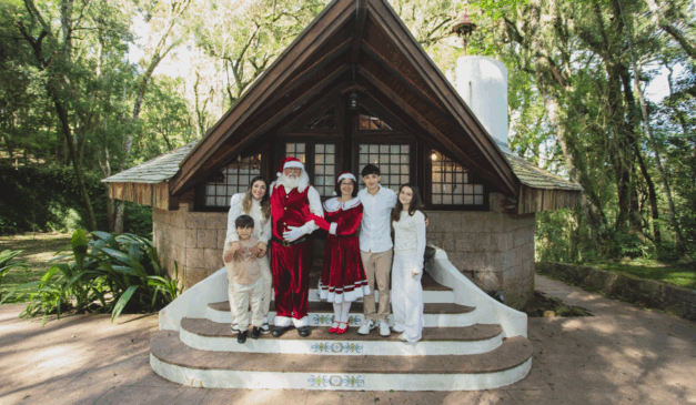 casa do papai noel em curitiba com família na frente durante sessão fotográfica