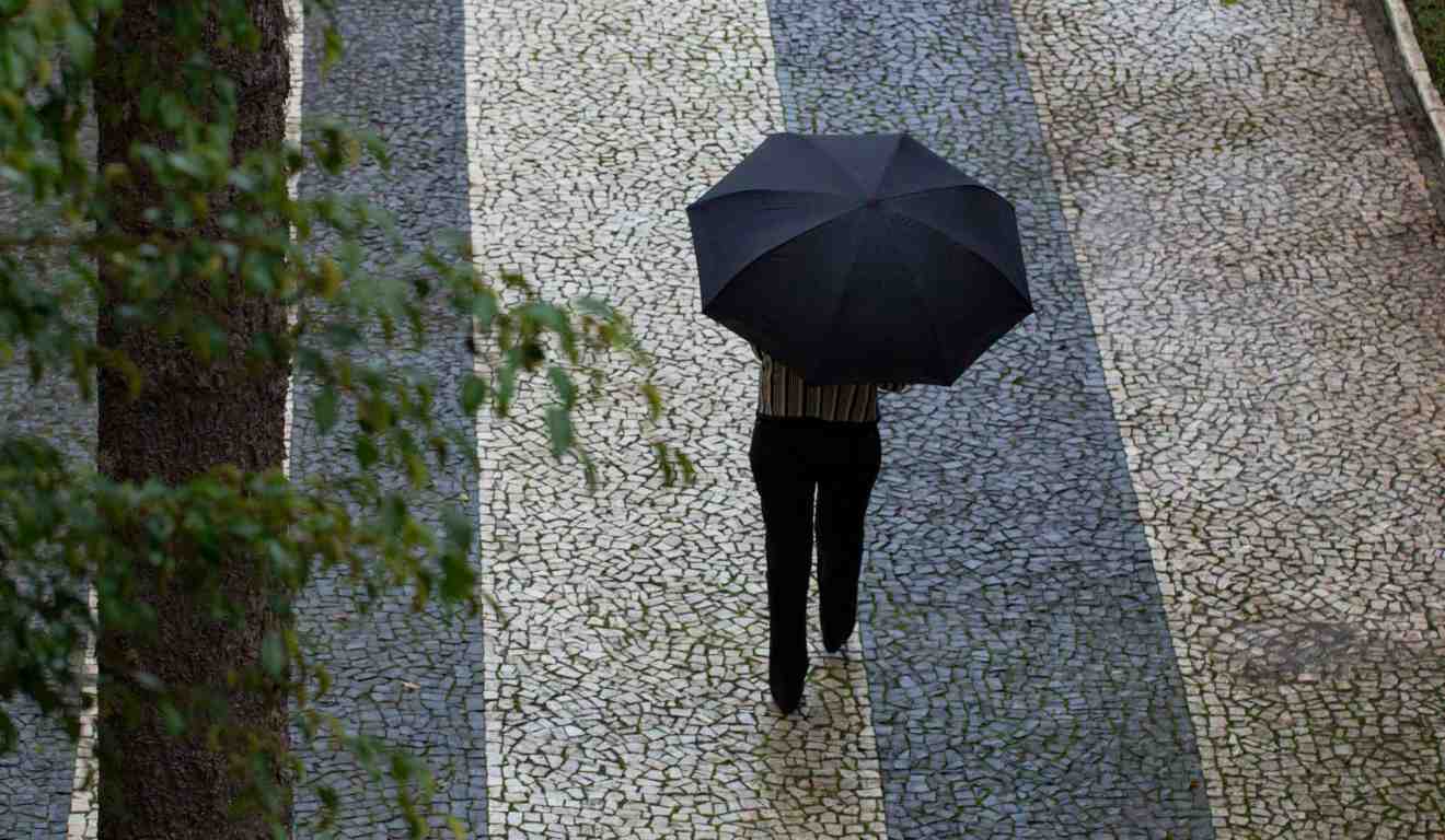 pessoas andando na chuva para ilustrar tempestade no paraná