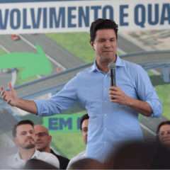 guto silva durante discurso público, no palco, com microfone