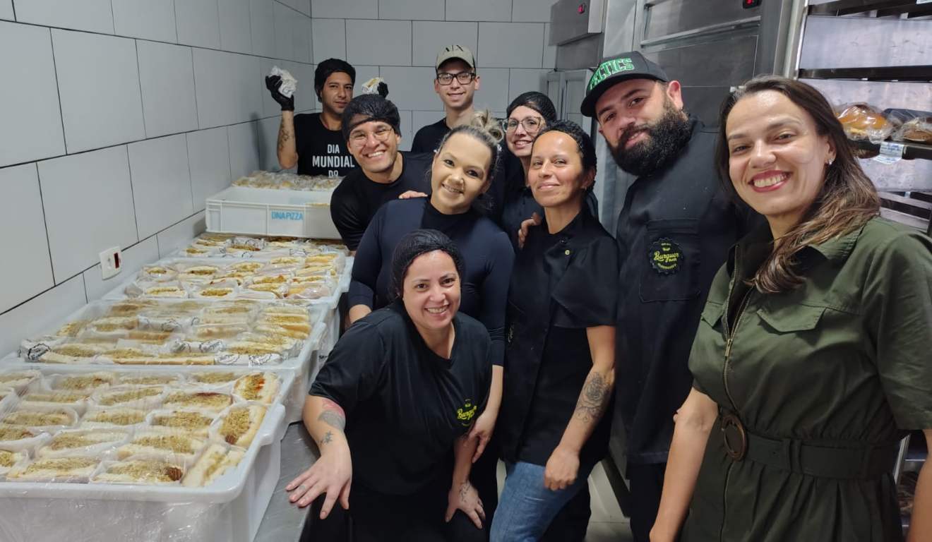 Funcionários do Burguer Bar em distribuição de hot dogs