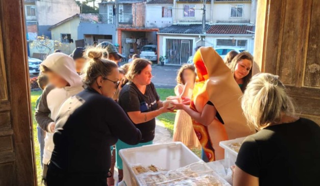 Funcionários do Burguer Bar em distribuição de hot dogs