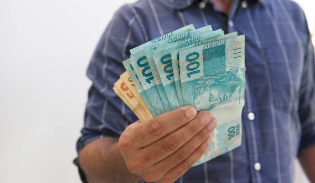 homem segurando dinheiro