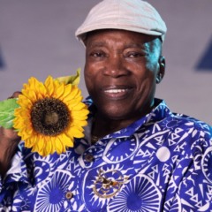 Milton Nascimento aparece sorridente com um girassol nas mãos