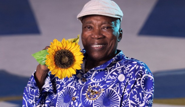 Milton Nascimento aparece sorridente com um girassol nas mãos