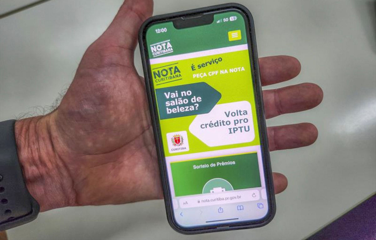 foto com celular mostrando aplicativo do Nota Curitibana