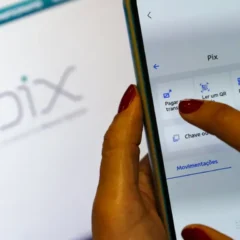 Saiba como funciona o Pix automático. Na imagem, vemos um celular com um aplicativo de banco, prestes a clicar no ícone "Pix".