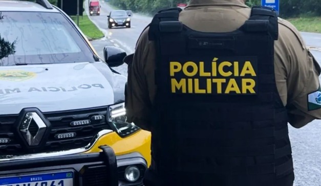 Policial militar de costas em uma rodovia