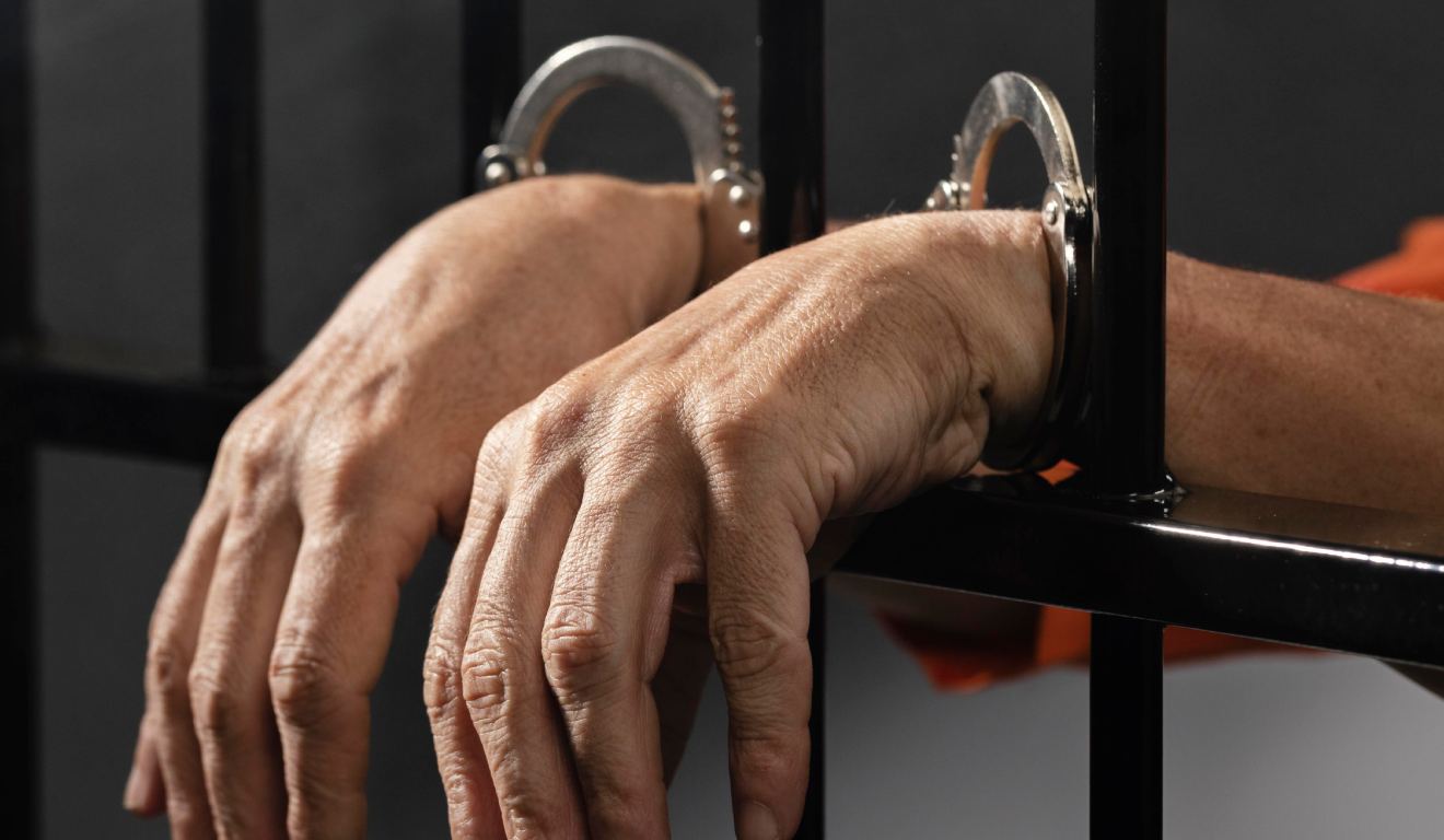 Homem algemado e preso em grade