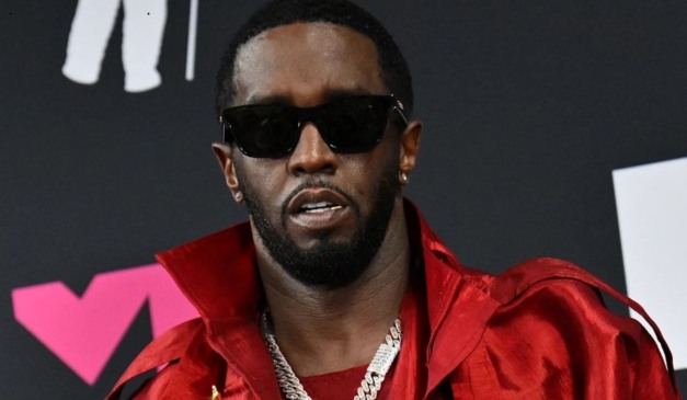 O rapper P. Diddy foi condenado nos EUA. Na imagem, vemos o empresário e cantor, um homem negro, de cabelo e barba pretos. Ele usa um óculos escuro e uma jaqueta vermelha.