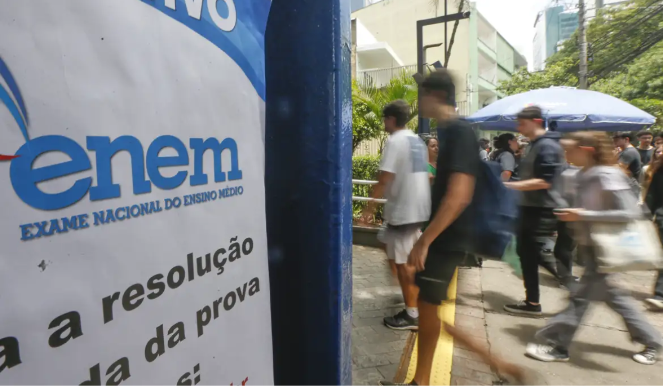 O Sisu 2026 aceitará as três últimas notas do Enem. Na imagem, vemos estudantes, borrados por estarem em movimento, entrando em um colégio onde será realizada a prova do Enem.