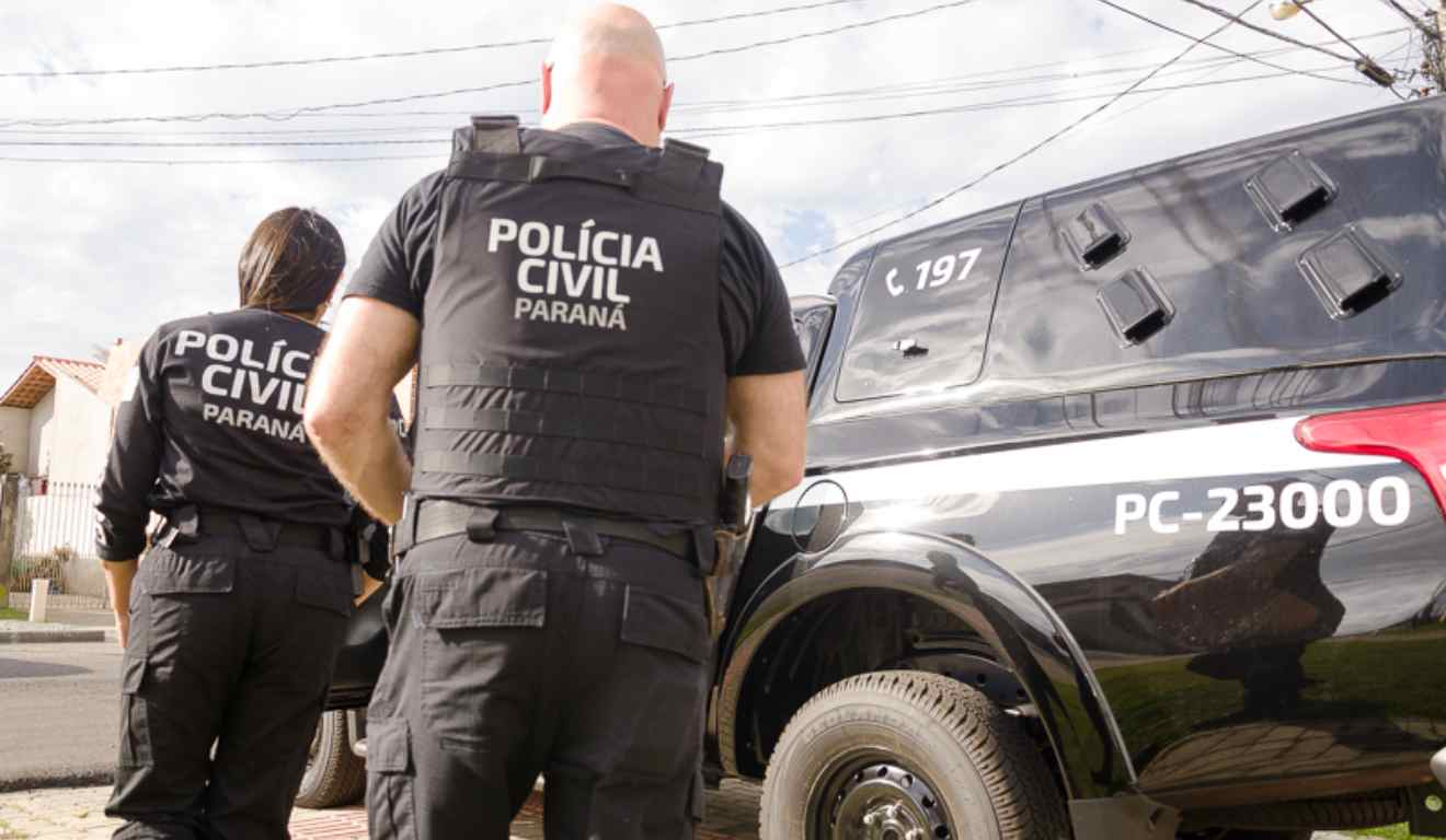 Políciais na frente de viatura da Polícia Civil