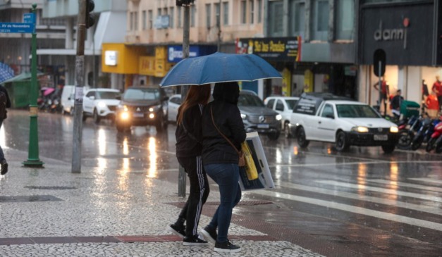 pessoas andando na chuva no Paraná